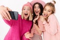 Image of beautiful girls smiling and taking selfie photo on cellphones Royalty Free Stock Photo