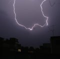 Image of thunder lightning against grey stormy sky with copy space