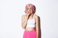 Image of timid cute girl in pink wig, looking indecisive and biting finger, standing over white background