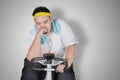 Tired obese man doing workout with exercise bike Royalty Free Stock Photo