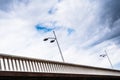 Image to use as an urban background of clouds and a handrail of a bridge with lampposts, copy space for text Royalty Free Stock Photo
