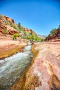 Tourists in red rock canyon with rapids river water running slide