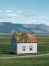 Traditional turf covered house in Glaumbaer, northwestern Iceland. Agricultural fields with horses, and snow-covered mountains in Royalty Free Stock Photo