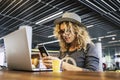 Image of traveler young trendy woman working with mobile phone and laptop in cafe bar coworking free wireless connection. Smart Royalty Free Stock Photo