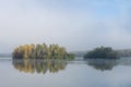 Image of tree island on the foggy lake at morning Royalty Free Stock Photo