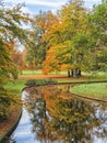 Trees in autumn colors reflected in the water of a canal