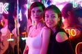 Image of two beautiful women in an amusement park in a room with neon light. Entertainment concept