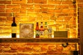 two bottles on a bar with brick walls and yellow lighting Royalty Free Stock Photo