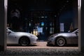 two cars parked in front of a building at night with lights lit on Royalty Free Stock Photo