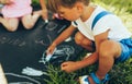 Image of two children sitting on the green grass playing with colorful chalks. Happy kids drawing with chalks in the park. Two Royalty Free Stock Photo