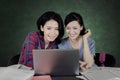 Two female students using a laptop in the classroom Royalty Free Stock Photo