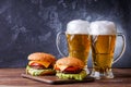 Image of two hamburgers, glasses with beer Royalty Free Stock Photo