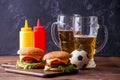 Image of two hamburgers, glasses, soccer ball, ketchup Royalty Free Stock Photo