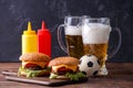 Image of two hamburgers, glasses, soccer ball, ketchup Royalty Free Stock Photo