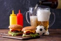 Image of two hamburgers, glasses, soccer ball, ketchup Royalty Free Stock Photo