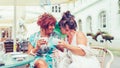 Two happy senior women friends sitting in cafe talking with each other while drinking coffee in a cafe Royalty Free Stock Photo