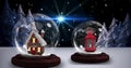 Image of two snow globes with house and christmas lantern with snow falling in winter scenery