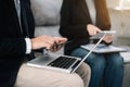 Image of two young businessmen using tablet and laptop computer at meeting. Royalty Free Stock Photo