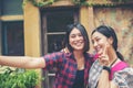 Image of two young happy women friends standing in urban city. Taking selfie Royalty Free Stock Photo