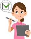 The upper body of a woman in a pink short-sleeved polo shirt and wearing a name tag, filling out a check sheet Royalty Free Stock Photo