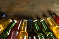 Image of various coloured glass beer bottles with crown caps lying on wood, with copy space