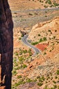 Vertical cliff wall with road curving through mountains in desert