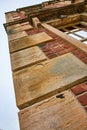 Vertical view of side of abandoned red brick mansion building and open sky background