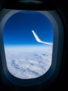 Image of view outside a flying airplane with wing, blue sky and clouds visible Royalty Free Stock Photo