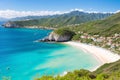 View of Picscina Natural Cueva from Las Palomas beach. Hill next to the ocean with small white houses on the