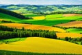 View to a valley with green and yellow agricultural cultivated fields, striped fields made with Generative AI