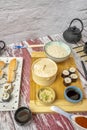 Image of vintage red paint table with plates of asian food and sushi. Steam dim sum basket, soy sauce, rice bowl, traditional Royalty Free Stock Photo