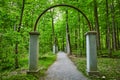 Walkway of roses, Rose Island park, forest, woodland, stone arches, archway, trail ending in woods Royalty Free Stock Photo