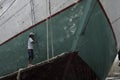 A man repainting the wooden boat