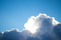 Clouds lit up by sun in blue sky