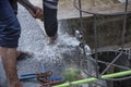 Washing hand,legs and plumbing tools with the burst water pipe splashing.