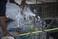 Washing hand,legs and plumbing tools with the burst water pipe splashing.