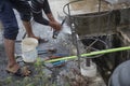 Washing hand,legs and plumbing tools with the burst water pipe splashing.