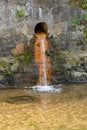 Water from sewer pipe flowing into the city canal Royalty Free Stock Photo