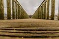 Image of a way on a wooden bridge leading to a gazebo in the middle of the lake