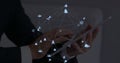 Image of web of connections with icons floating over hands of a man using a digital tablet Royalty Free Stock Photo