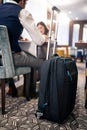 Image of wheeled suitcase in hotel with people in the background having lunch