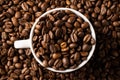 Image of white cup full of coffee beans on pile of coffee beans Royalty Free Stock Photo