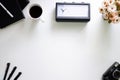 Image of White Office Desk with Computer Keyboard, coffee , clock, flowers ,Pen , Booklets and other Supplies Top View