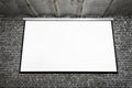 Image of white projector screen on gray brick wall Royalty Free Stock Photo