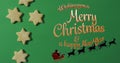 Image of wishing you merry christmas text over coopkies and santa sleigh on green background Royalty Free Stock Photo