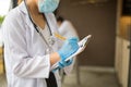 image of woman doctor in white coat with stethoscope and blue glove write report by pencil in a notebook on blur background of ho Royalty Free Stock Photo