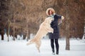 Image of woman playing with labrador in snowy park