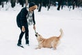 Image of woman playing with labrador in winter park