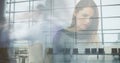 Image of woman working on laptop at home over sped up commuters walking in modern building