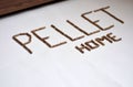 Image of wood pellet fuel grains on white background forming letters and home